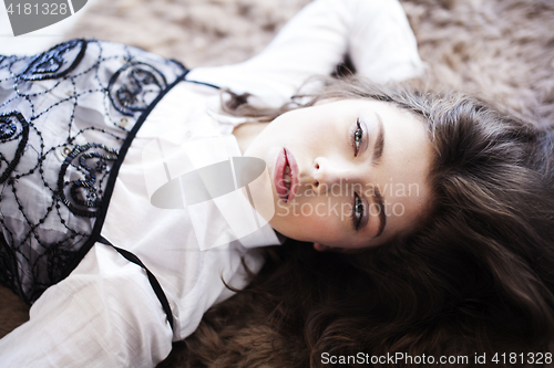 Image of young pretty woman in her bedroom sitting in chair, lifestyle people concept