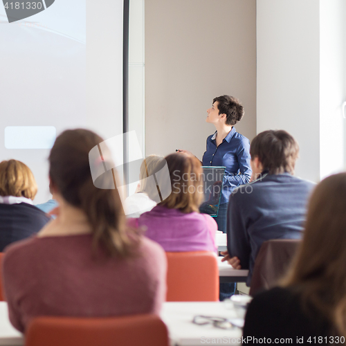 Image of Woman giving presentation in lecture hall at university.