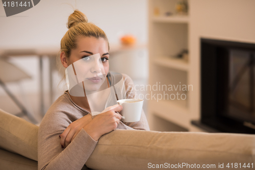 Image of woman with a mug near a fireplace