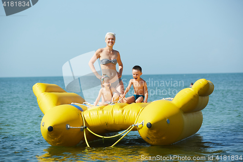 Image of two children with mom on the dinghy sailing at sea in summer