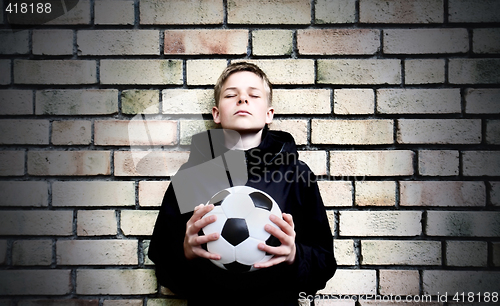 Image of A boy against a wall with a ball