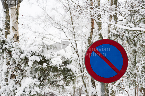 Image of No parking roadsign surrounded of snow