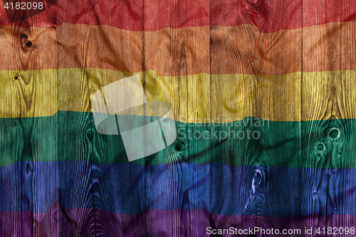 Image of Rainbow flag, wooden background