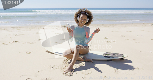 Image of Female listening music on beach