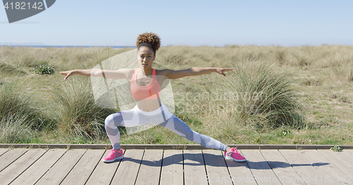 Image of Sporty woman stretching on pavement