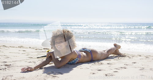 Image of Smiling female sunbathing on beach 