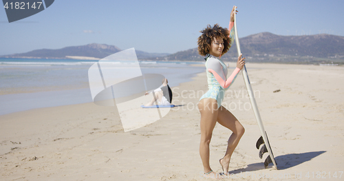 Image of Female posing with surfboard on beach