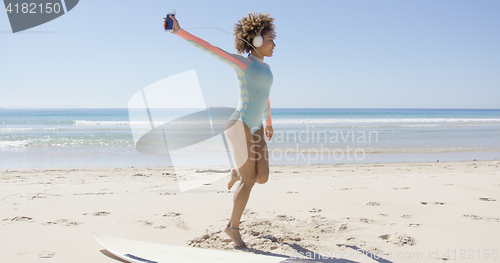 Image of Female listening to music on beach