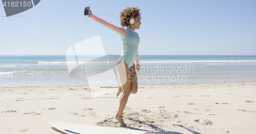Image of Female listening to music on beach