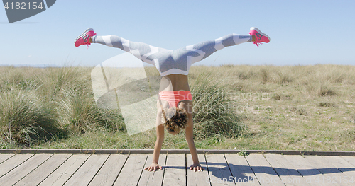 Image of Woman standing on on hands