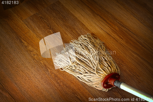 Image of washing the wood floor with an old mop