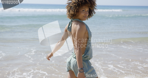 Image of Female wearing summer jumpsuit posing on beach