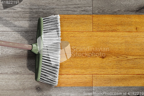 Image of sweeping wooden floor with broom