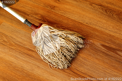 Image of old mop on wooden parquet