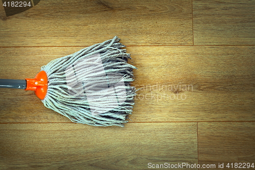 Image of closeup of mop head cleaning on wooden parquet