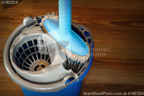 Image of mop and blue bucket ready for cleaning floor