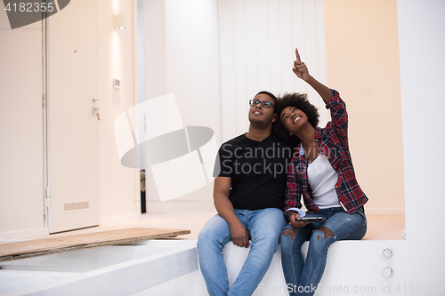 Image of couple having break during moving to new house