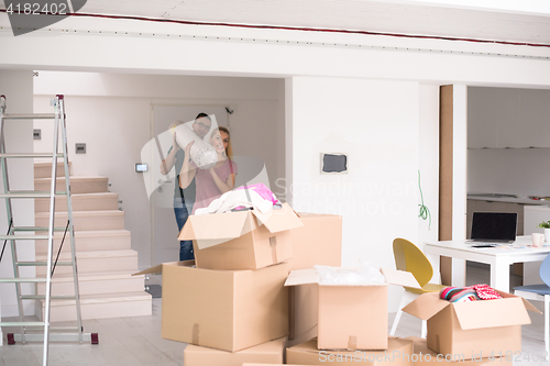 Image of couple carrying a carpet moving in to new home