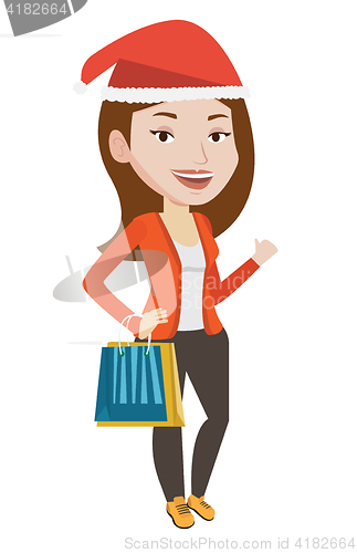 Image of Woman in santa hat shopping for christmas gifts.