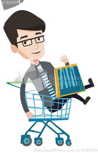 Image of Happy man riding by shopping trolley.