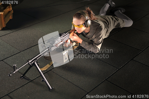 Image of Shooting range. A woman with a machine gun.