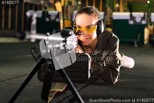 Image of Shooting range. A woman with a machine gun.