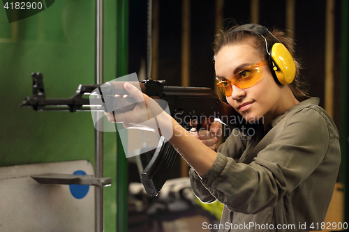 Image of Woman in vest shot at the shooting range with a rifle