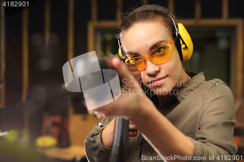 Image of The woman at the shooting range. Woman shoots a rifle at the shooting range