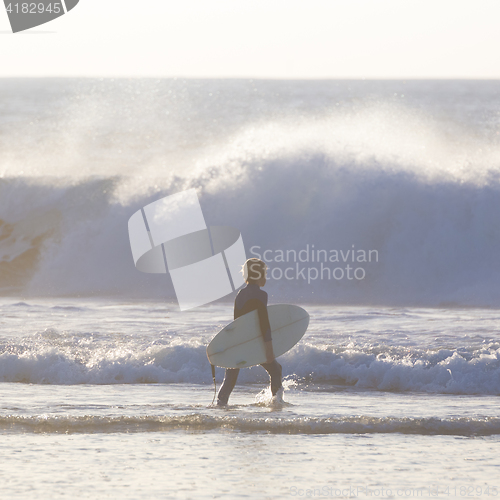 Image of Surfers on beach with surfboard.