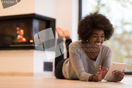 Image of black women used tablet computer on the floor