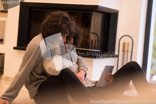 Image of multiethnic couple used tablet computer on the floor