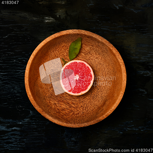 Image of Grapefruit citrus fruit halves on wooden plate