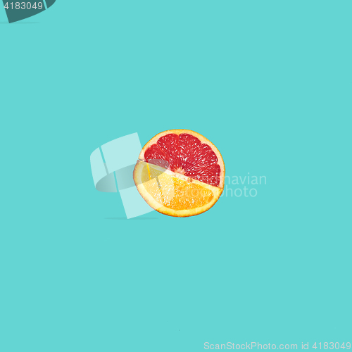 Image of Grapefruit and orange citrus fruit halves on blue