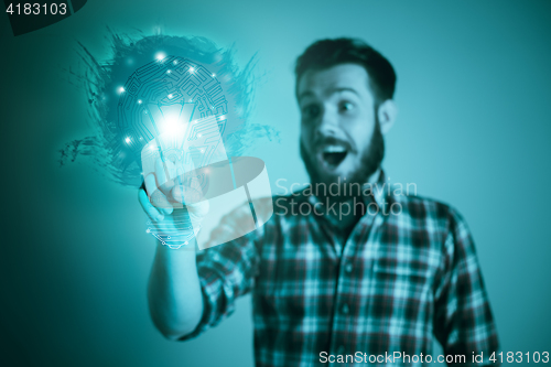 Image of Handsome young man with idea bulb on blue
