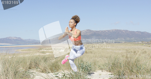 Image of Woman doing yoga on the beach