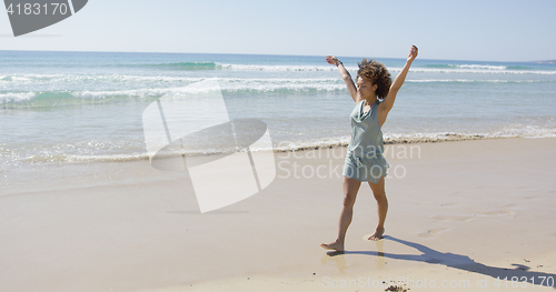 Image of Female walking along the shore of beach