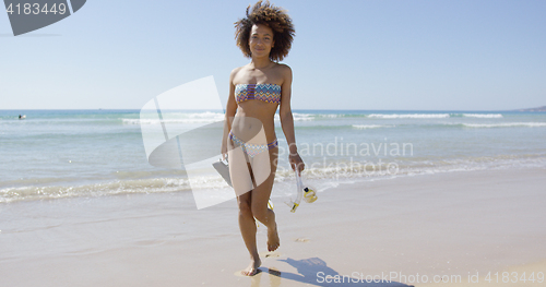 Image of Female with flippers walking on beach