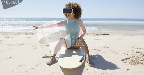 Image of Female wearing virtual reality glasses on beach