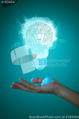 Image of Hands of business person holding illuminated light bulb sign
