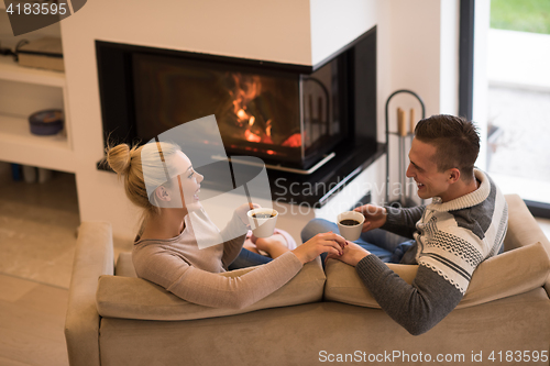 Image of Young couple  in front of fireplace