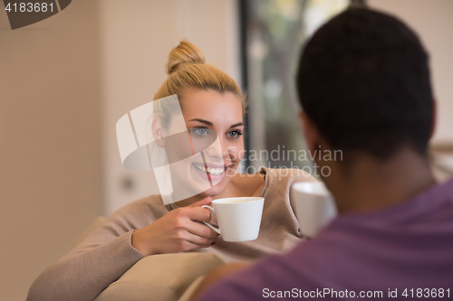 Image of Young multiethnic couple  in front of fireplace