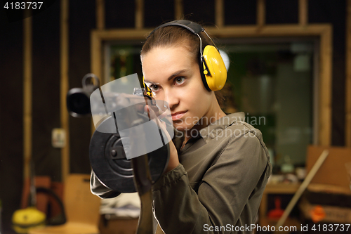 Image of Shooting range. A woman with a machine gun.