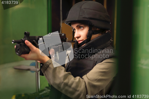 Image of Woman in vest shot at the shooting range with a rifle