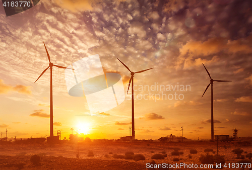 Image of Wind generator turbines sihouettes on sunset