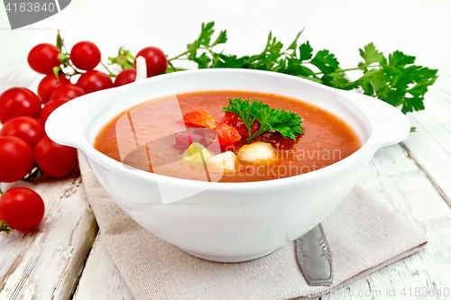 Image of Soup tomato in white bowl with vegetables on towel