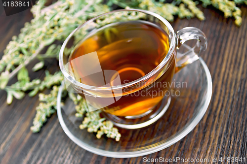 Image of Tea with wormwood in glass cup on dark board