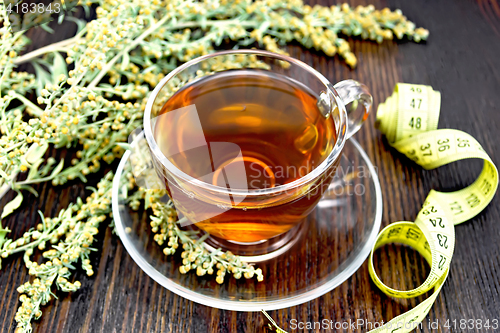 Image of Tea with wormwood in glass cup and meter on board