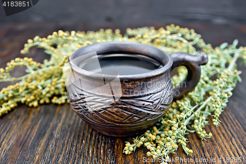 Image of Tea with wormwood in cup on board