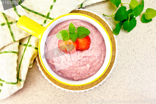 Image of Soup strawberry in yellow bowl on granite table top