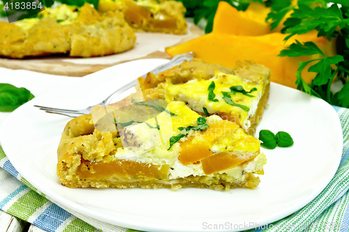 Image of Pie of pumpkin and cheese in white plate on napkin